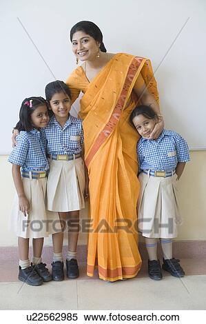 Portrait of a teacher standing with three students and smiling View Large Photo Image Stock Photography - Portrait of a teacher standing with three students and smiling. Fotosearch