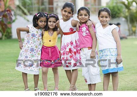 Stock Photograph - Portrait of five girls standing in a lawn. Fotosearch