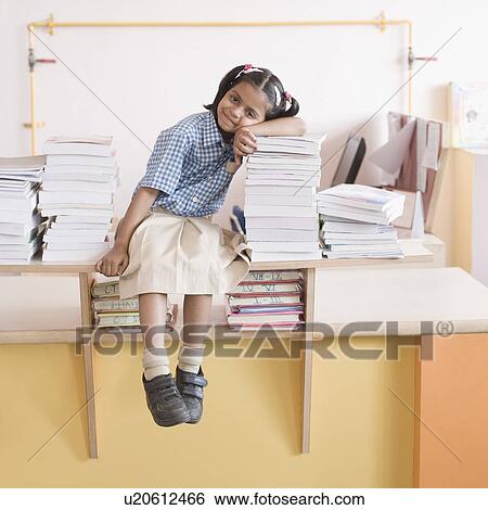 Schoolgirl sitting on a shelf and leaning against a stack of books View Large Photo Image Stock Photograph - Schoolgirl sitting on a shelf and leaning against a stack of books. Fotosearch