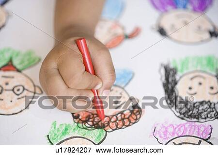 Stock Photo - Close-up of child's hand drawing on a sheet of paper. Fotosearch