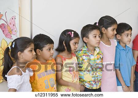 Group of students standing in a row in the classroom View Large Photo Image Stock Photography - Group of students standing in a row in the classroom. Fotosearch