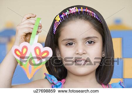 Portrait of a girl holding a paper craft product View Large Photo Image Stock Photo - Portrait of a girl holding a paper craft product. Fotosearch