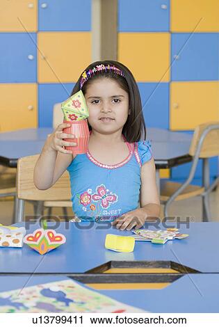 Stock Image - Portrait of a girl holding paper craft products. Fotosearch