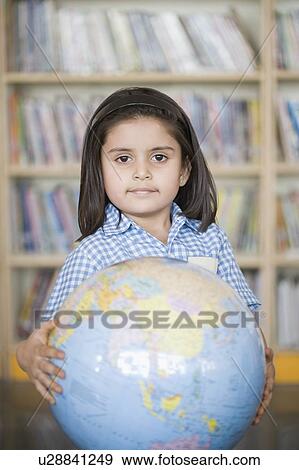 Stock Photo - Portrait of a schoolgirl holding a globe. Fotosearch