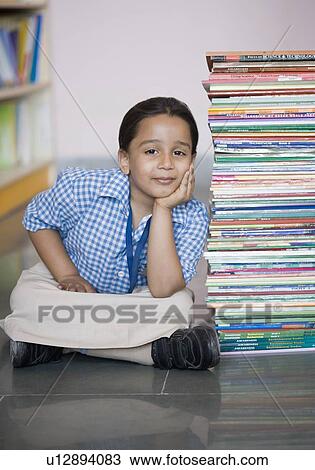 Portrait of a schoolgirl sitting on the floor with a stack of books View Large Photo Image Stock Image - Portrait of a schoolgirl sitting on the floor with a stack of books. Fotosearch