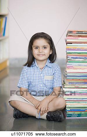 Portrait of a schoolgirl sitting on the floor with a stack of books View Large Photo Image Stock Photography - Portrait of a schoolgirl sitting on the floor with a stack of books. Fotosearch