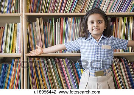 Portrait of a schoolgirl standing in a library with her arms outstretched View Large Photo Image Stock Image - Portrait of a schoolgirl standing in a library with her arms outstretched. Fotosearch