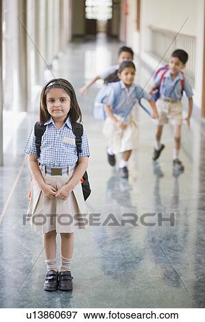 Portrait of a schoolgirl standing in the corridor with three student running in the background View Large Photo Image Stock Photo - Portrait of a schoolgirl standing in the corridor with three student running in the background. Fotosearch