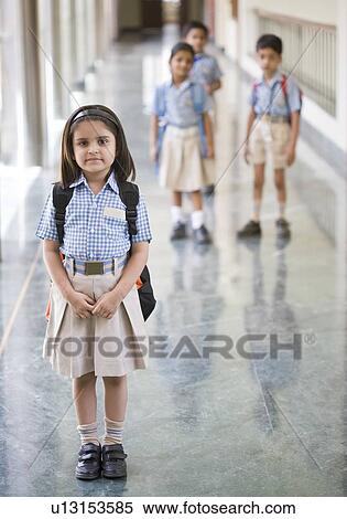 Stock Photography - Portrait of a schoolgirl standing in the corridor of a school. Fotosearch