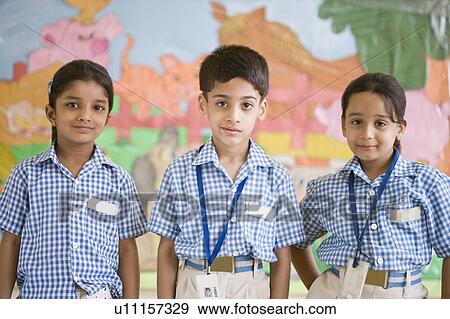Stock Photo - Portrait of three schoolchildren standing in a row. Fotosearch