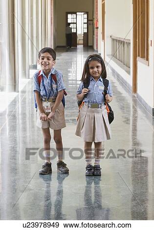 Stock Photo - Schoolgirl and a schoolboy standing at the corridor of a school. Fotosearch