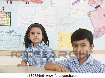 Stock Photograph - Two school children in a classroom. Fotosearch