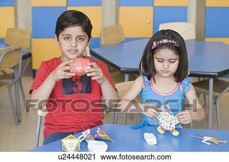 Two students making paper craft products in a classroom View Large Photo Image Stock Image - Two students making paper craft products in a classroom. Fotosearch