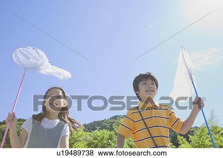 Stock Photo - Boy and Girl Holding Butterfly Net. Fotosearch