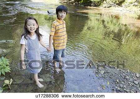 Stock Photograph - Boy and Girl Playing with Water. Fotosearch