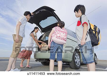 Stock Image - Family Opening Trunk of a Car. Fotosearch