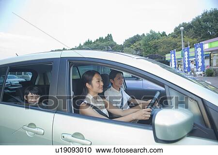 Stock Image - Family Parking a Car at Service Area. Fotosearch
