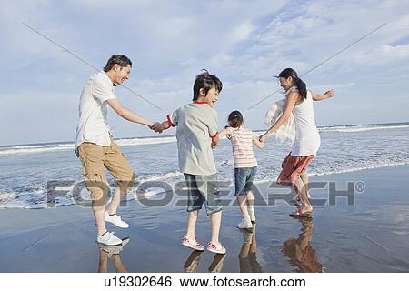 Stock Photograph - Family Playing at Beach. Fotosearch