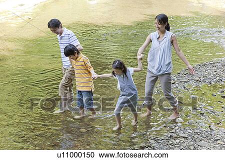 Stock Image - Family Playing with Water. Fotosearch