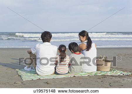 Stock Photo - Family Sitting at Beach. Fotosearch