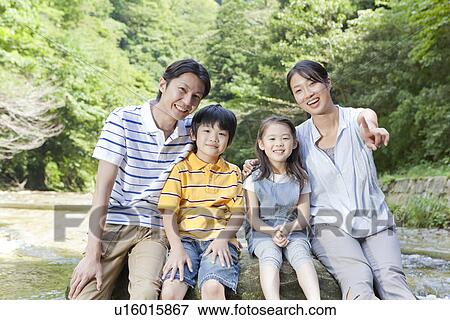 Stock Photo - Family Sitting on Rock. Fotosearch