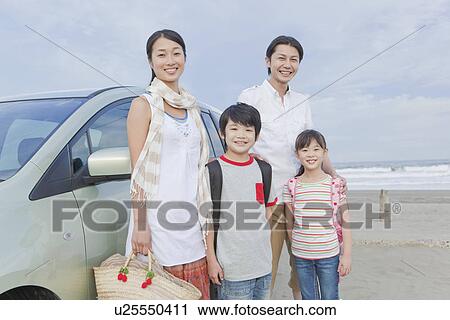 Stock Image - Family Standing in front of a Car. Fotosearch