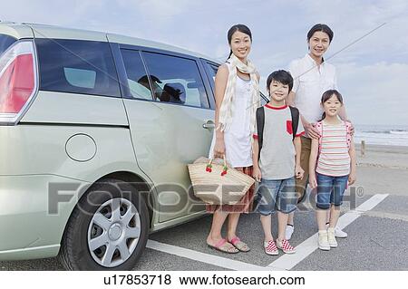 Stock Photo - Family Standing in front of a Car. Fotosearch