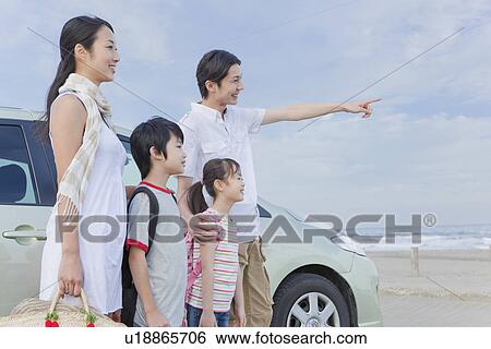 Stock Photograph - Family Standing in front of a Car. Fotosearch