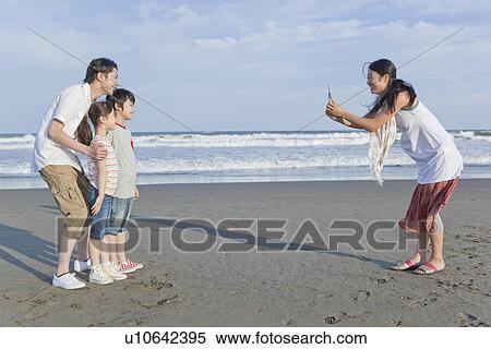 Stock Photography - Family Taking Photo by Cellular Phone at Beach. Fotosearch