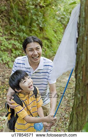 Stock Image - Father and Son Catching Insects. Fotosearch