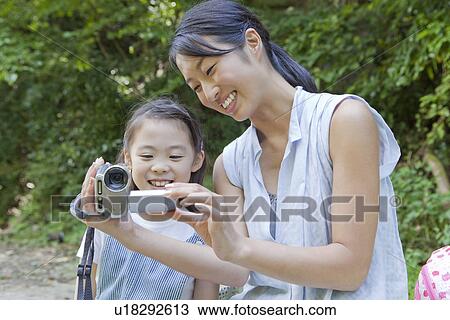 Stock Image - Mother and Daughter Watching Homemade Video. Fotosearch