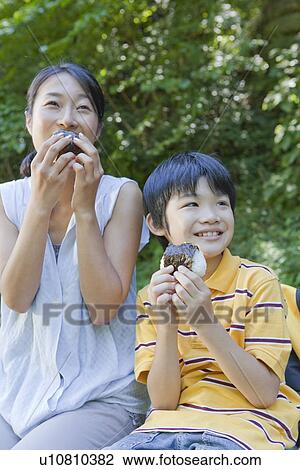 Stock Image - Mother and Son Eating Rice Ball. Fotosearch