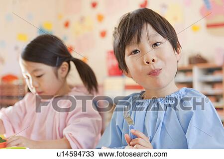 Stock Image - Kindergarten Children Having Lunch. Fotosearch