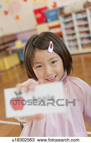 Stock Image - Kindergarten Girl Holding Picture Card. Fotosearch