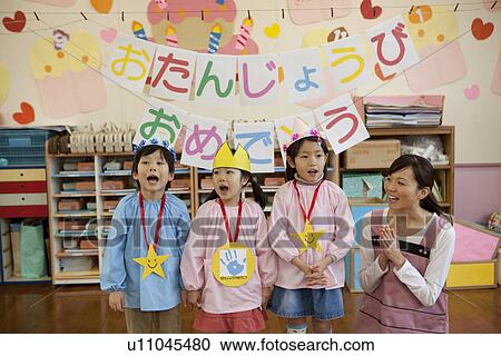 Stock Image - Kindergarten Teacher and Children Celebrating Birthday. Fotosearch