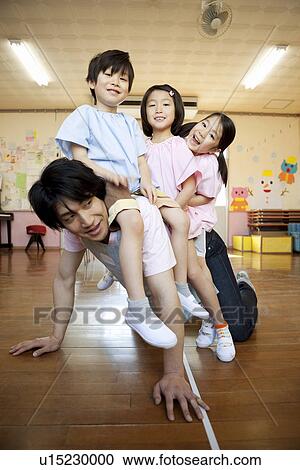 Stock Image - Kindergarten Teacher and Children Playing. Fotosearch