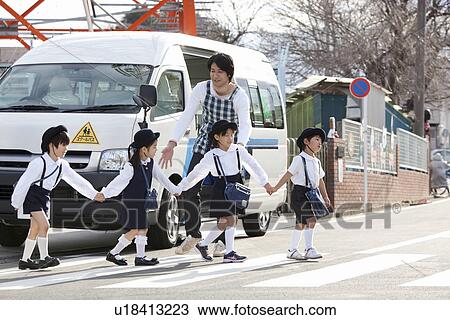 Stock Image - Kindergarten Teacher and Children Walking in front of School Bus. Fotosearch