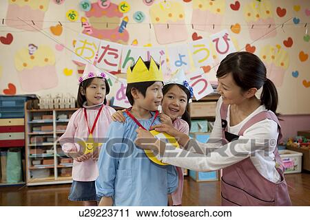 Stock Image - Kindergarten Teacher and Children Celebrating Birthday. Fotosearch