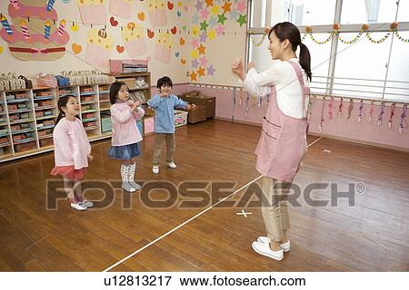 Stock Photo - Kindergarten Teacher and Children Playing. Fotosearch