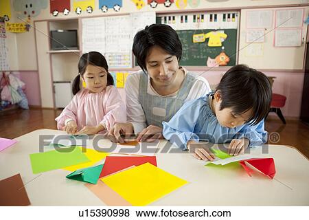 Kindergarten Teacher and Children Playing Origami View Large Photo Image Stock Photo - Kindergarten Teacher and Children Playing Origami. Fotosearch