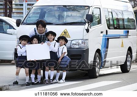 Stock Photograph - Kindergarten Teacher and Children Standing in front of School Bus. Fotosearch
