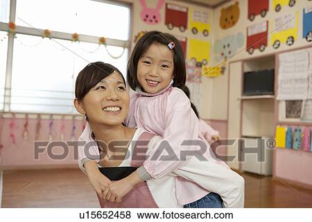 Kindergarten Teacher Carrying Children on Back View Large Photo Image Stock Photo - Kindergarten Teacher Carrying Children on Back. Fotosearch