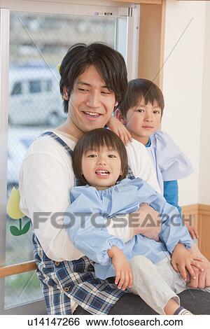 Stock Photograph - Kindergarten Teacher Holding Kids. Fotosearch
