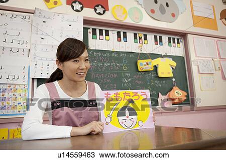 Stock Image - Kindergarten Teacher Showing Picture Card Show to Children. Fotosearch