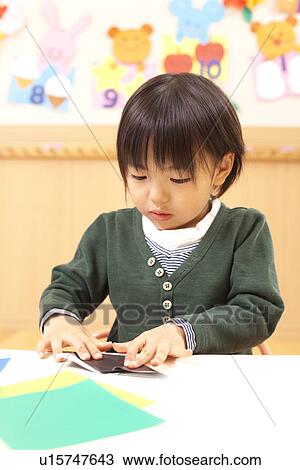 Stock Image - Boy Playing Origami. Fotosearch