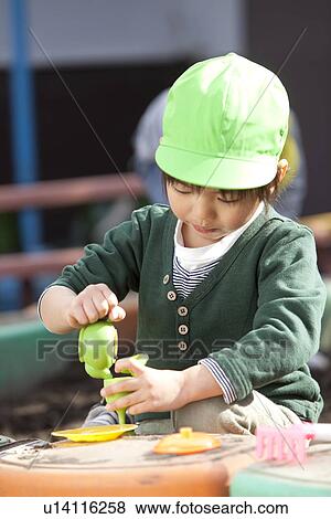 Stock Photo - Boy Playing with Sand. Fotosearch