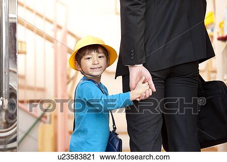 Stock Image - Businessman Picking Up Son from Day-care Center. Fotosearch