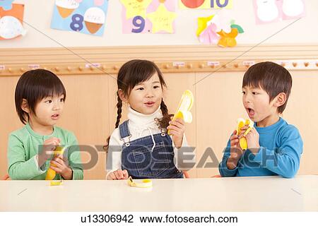 Stock Image - Children Eating Banana. Fotosearch