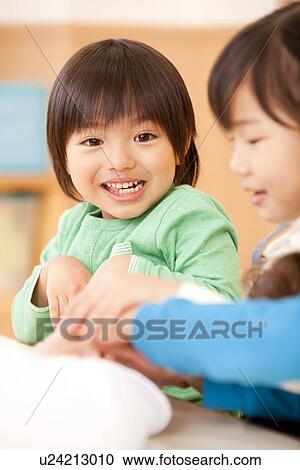 Stock Image - Children Playing with Nursery Teacher. Fotosearch