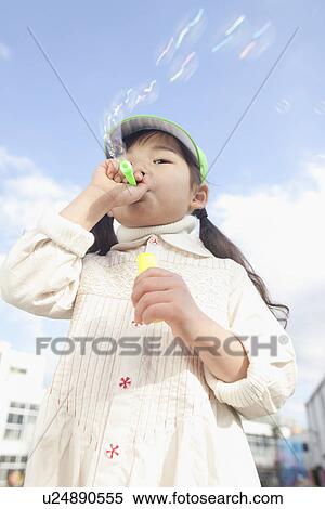 Stock Photography - Girl Blowing Soap Bubbles. Fotosearch